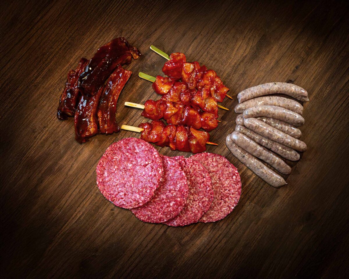 Selection of meat products including beef burgers, pork sausages, BBQ pork spare ribs, and Chinese-style chicken kebabs