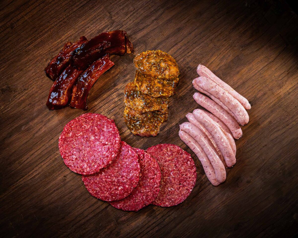 Selection of meat products including beef burgers, sausages, lemon and chilli pork steaks, and BBQ pork spare ribs
